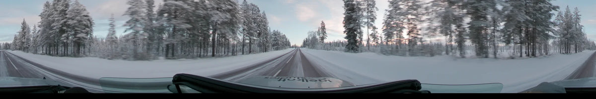 Frosted forests flank a road in Grövelsjön, Sweden. This view from a car captures the landscape on a partly cloudy winter afternoon.