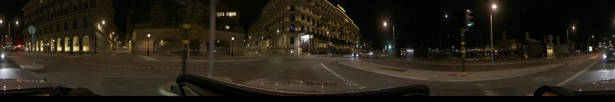 The lit facade of the Grand Hôtel overlooks a street in Stockholm, Sweden, as a car drives by during a clear autumn night.