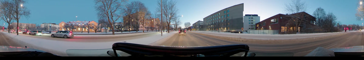 Snowy roads and a blend of modern and older architecture characterize this car journey through Uppsala, Sweden, on a clear winter afternoon.