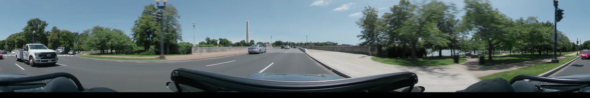 A car travels through Washington, United States, on a clear spring day, with the Washington Monument in view beside the road.