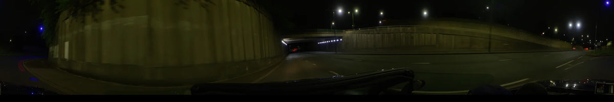 Bright white lights line the walls of a concrete underpass as a car drives through on a clear spring night in London, United Kingdom.
