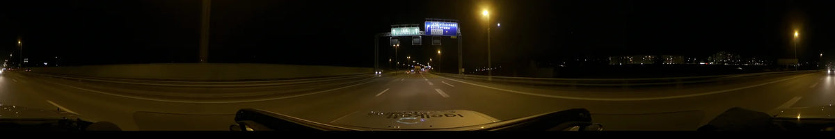 A clear autumn night drive on the E18 highway in Stockholm, Sweden. The view from a car shows overhead signs for Sollentuna, Vällingby, and Tensta.