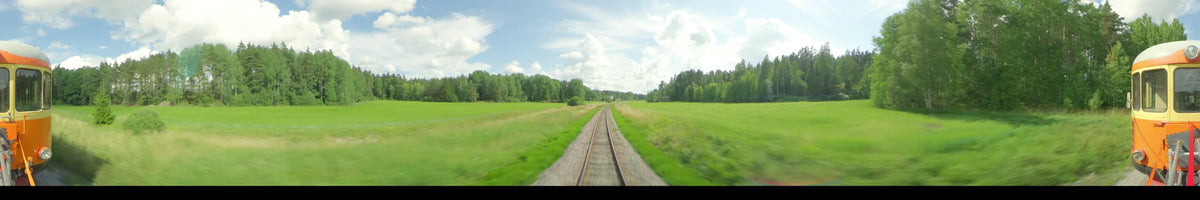 A daytime view from a train moving through the summer countryside of Uppsala, Sweden, featuring railway tracks surrounded by green fields and forests under a partly cloudy sky.
