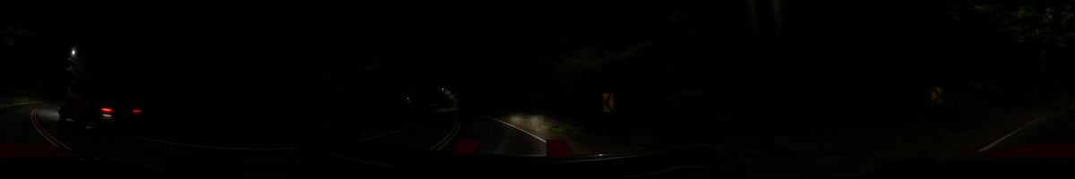 Nighttime driving view from a car on a winding road in Washington, United States, during a clear spring night, with headlights cutting through the darkness.