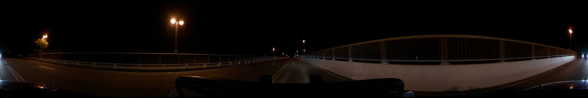 A clear spring night in Washington, United States, as seen from a car. The road is flanked by railings and lit by streetlamps.
