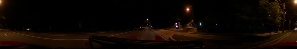 Driving through Washington, United States, on a clear spring night. The perspective from a car captures a glowing roadside sign and the taillights of another vehicle.